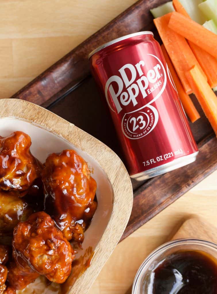 air fryer Dr Pepper Hot Wings next to a can of dr pepper and extra sauce