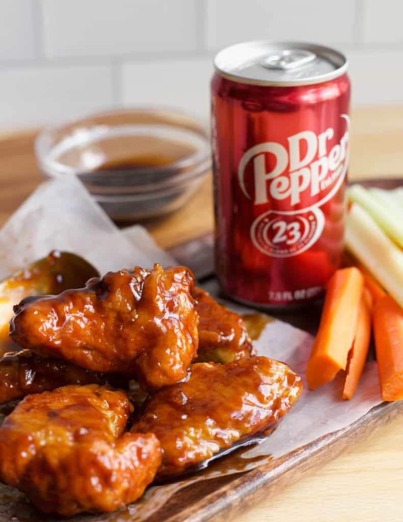 Air Fryer Dr Pepper Hot Wings on a plate next to a can of Dr Pepper