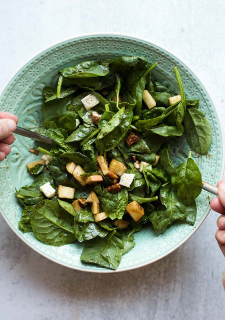 Tossing Apple Brie Pecan Salad.