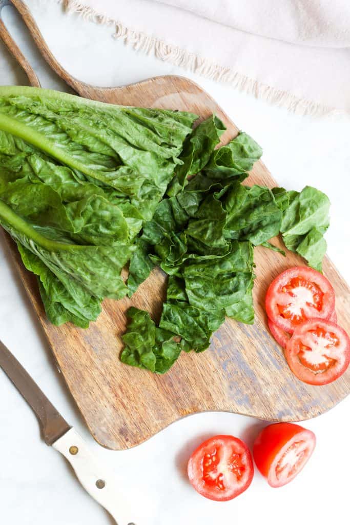 romaine lettuce and tomatoes being cut