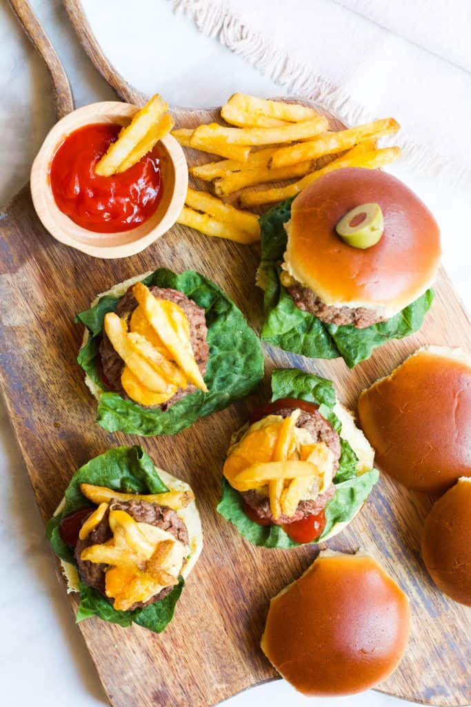 Mini Burger Sliders on a cutting board with fries and ketchup