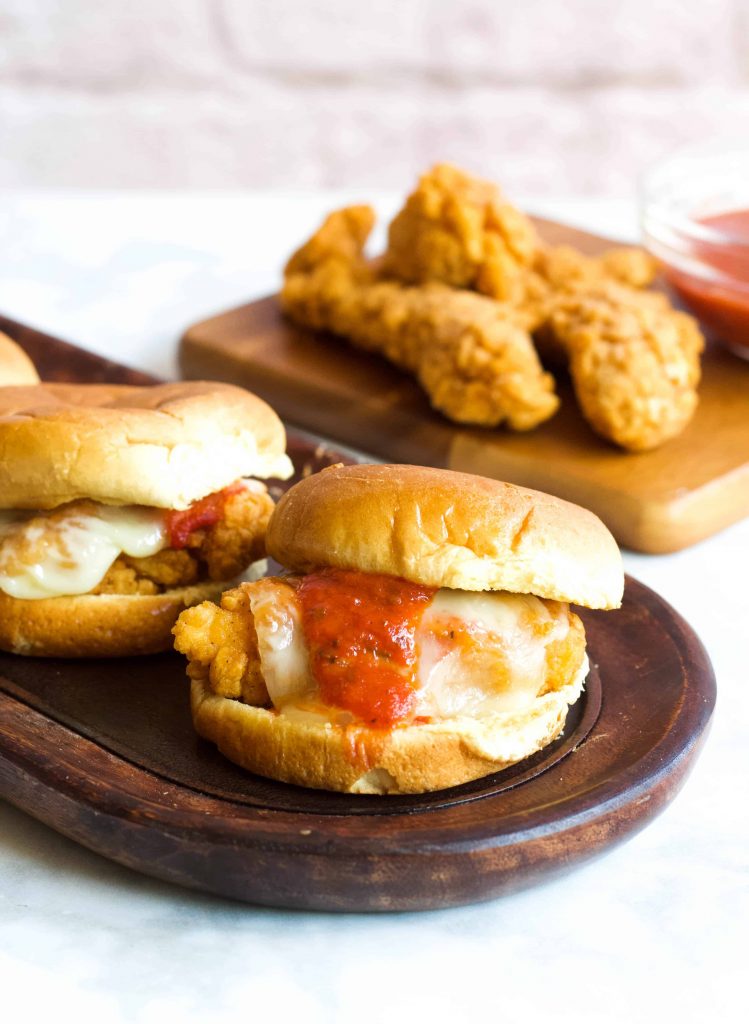 Parmesan Chicken Sliders topped with pizza sauce and melted mozzarella