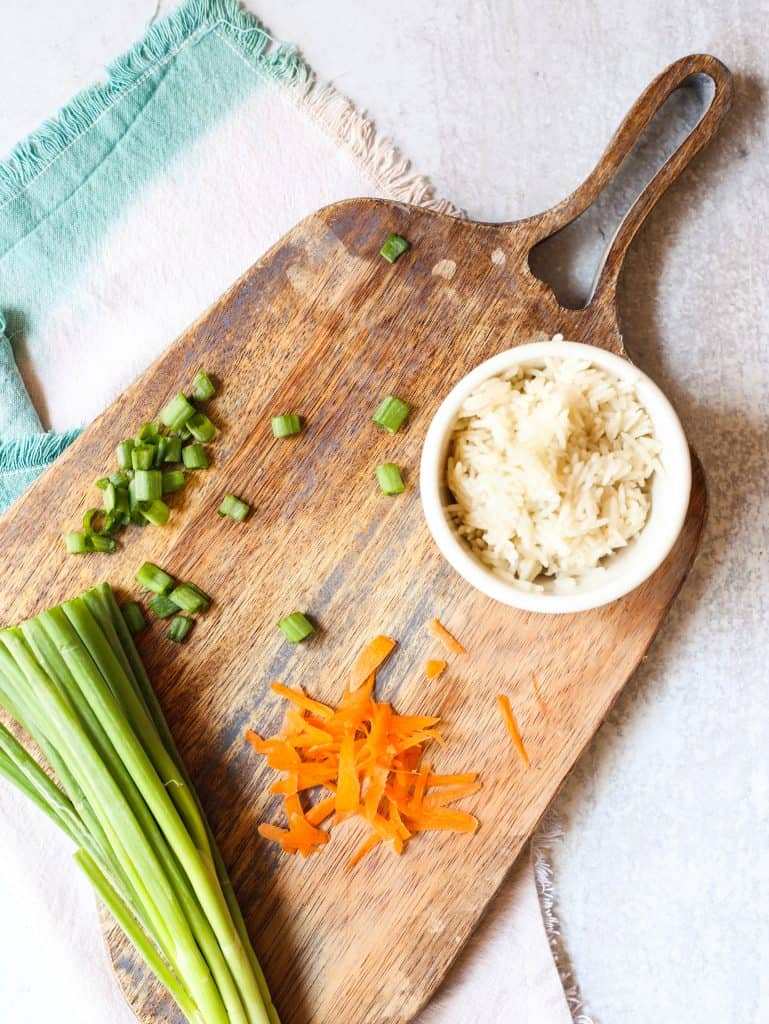 rice, scallions and carrots on a cutting board
