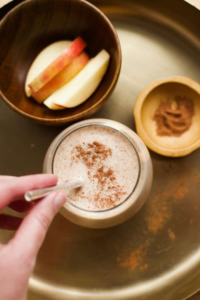 Hand stirring straw in Apple Pie Smoothie.