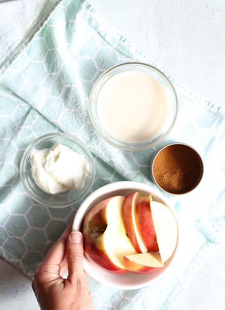 bowl of cut up apples, bowl of greek yogurt, and bowl of almond milk