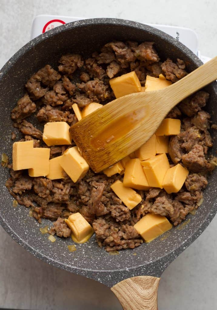 velveeta cheese and sausage cooking in a skillet