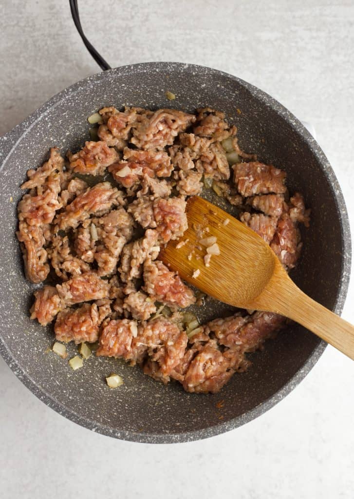 sausage and onion cooking in a skillet