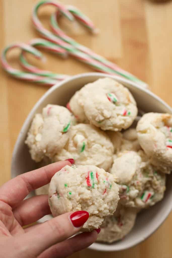 Hand holding a festive candy cane cookie made with cake mix.